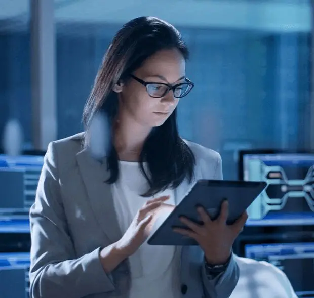 A woman in glasses is holding an ipad